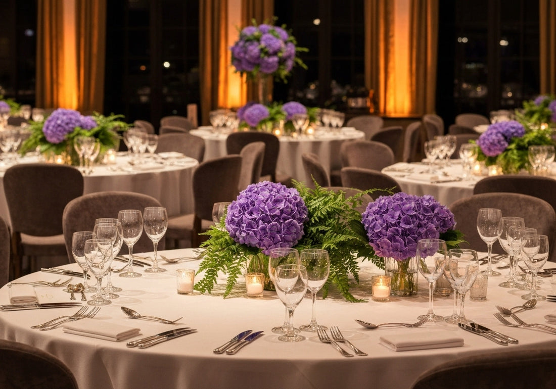 An elegant wedding reception hall with carefully arranged round tables, floral centerpieces, and a festive atmosphere.