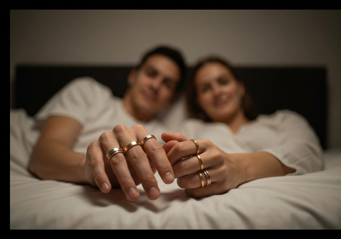 A married couple lying in bed at night, holding hands with various types of wedding rings visible on their fingers.