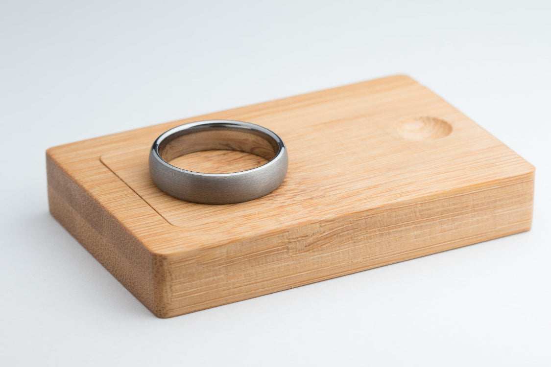Tungsten wedding ring on a wooden box against a white background