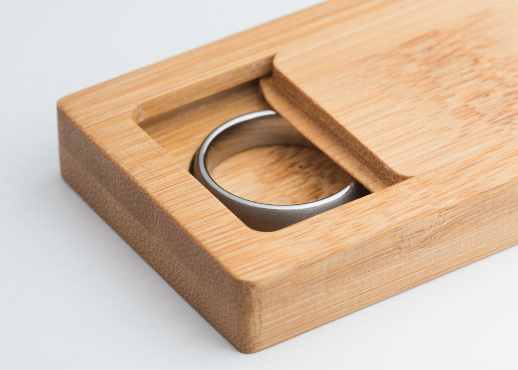 Tungsten wedding ring in a wooden box on a light gray background