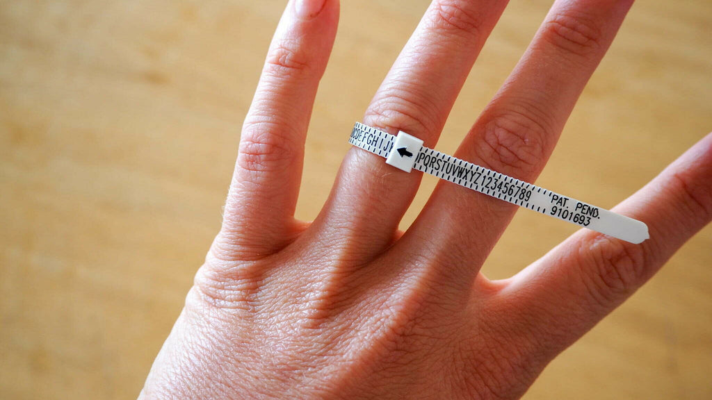 Hand wearing a ziptie-like ring sizing kit