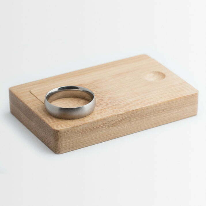 Titanium wedding ring sitting on wooden box