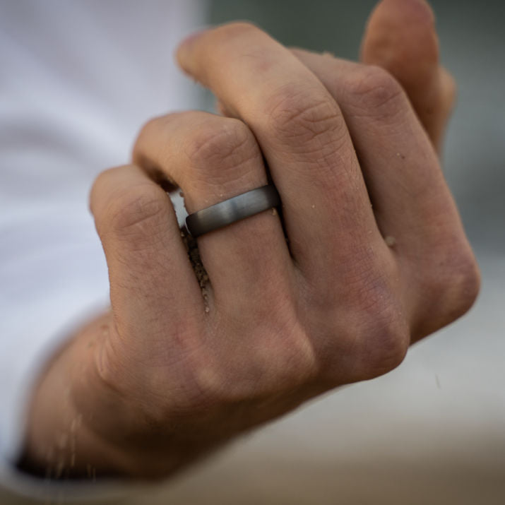 Close-up of a hand wearing a wedding ring with a blurred background